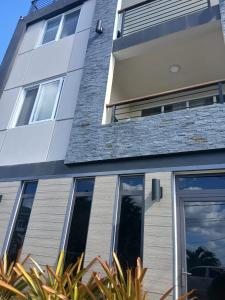 un bâtiment avec de grandes fenêtres et des plantes devant lui dans l'établissement Cypress Suites, à Goodwill