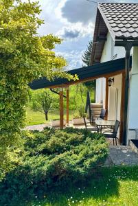 eine Terrasse mit Tisch und Bänken auf einem Haus in der Unterkunft Apartments Sanja in Rakovica