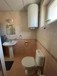 a bathroom with a toilet and a sink at Къща за гости НИКА in Kavarna