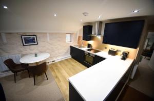 a kitchen with a table and a tv on the wall at Katie Ann's Thatched Cottage in Luib