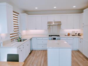 una cucina bianca con mobili bianchi e un lavello di FB Master a Irvine