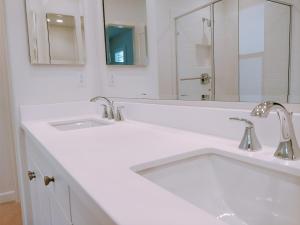 un bagno bianco con lavandino e specchio di FB Master a Irvine