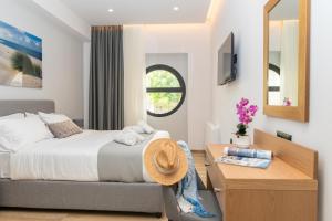 a bedroom with a bed and a desk and a mirror at Ameda Luxury Apartments in Kos Town