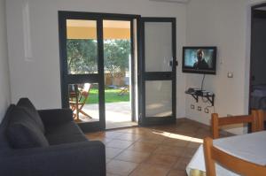 uma sala de estar com uma porta que abre para um pátio em Villette Via Carbonia em Budoni