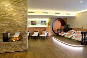 a woman sitting in a waiting room with a fireplace at Ferienhotel Hofer superior in Strass im Attergau