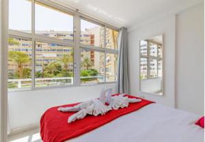 a bedroom with a bed with a red blanket and windows at AH - Rayito II - Confort y diseño bajo el sol de Maspalomas in Maspalomas