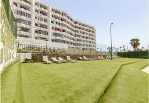 a large building with chairs and a grass field at AH - Rayito II - Confort y diseño bajo el sol de Maspalomas in Maspalomas