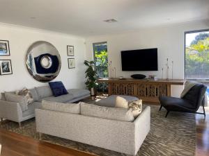 a living room with two couches and a flat screen tv at MiaMia Ultra Modern Home with Pool and Courtyard in Perth