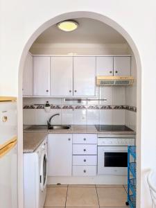 a kitchen with white cabinets and an archway at Estudio en Paraiso Royal in Arona