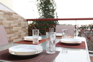a table with plates and glasses on a table at Holiday Apartment Fourka in Skala Fourkas +33 photos
