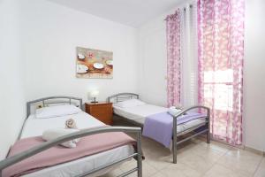 two twin beds in a room with a window at Holiday Apartment Fourka in Skala Fourkas