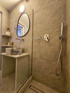 eine Dusche mit Glastür und Spiegel in der Unterkunft Twins Apartments By Mina in Ornos