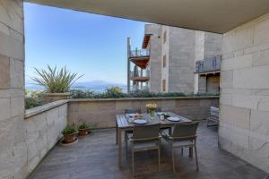 a patio with a table and chairs on a balcony at MGH Luxury - Residenza La Perla Peschiera Lakefront in Peschiera del Garda
