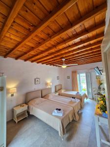 ein Schlafzimmer mit zwei Betten und einer Holzdecke in der Unterkunft Twins Apartments By Mina in Ornos
