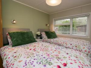 a bedroom with two beds and a window at Robin's Lodge in Windermere