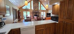 斯旺顿Tall Pines- 5-bedroom 3-bath with hot tub and more!的一间带木制橱柜的厨房和一间客厅