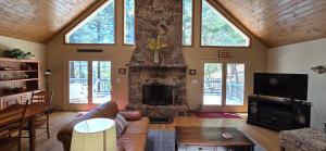 斯旺顿Tall Pines- 5-bedroom 3-bath with hot tub and more!的带沙发和石壁炉的客厅
