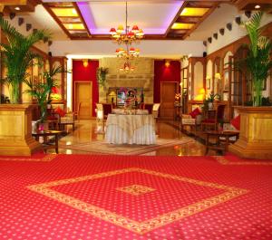 een grote lobby met een rood tapijt op de vloer bij Manoir De Kertalg in Moëlan-sur-Mer