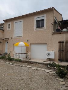 una casa con un ombrellone e un garage bianco di studio ensoleillé a Beaucaire
