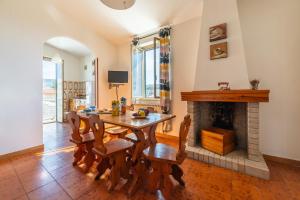 a dining room with a table and a fireplace at AffittaSardegna - Quadri Alba in Castelsardo