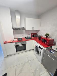a kitchen with a washing machine and a red counter top at AH - Rayito II - Confort y diseño bajo el sol de Maspalomas in Maspalomas