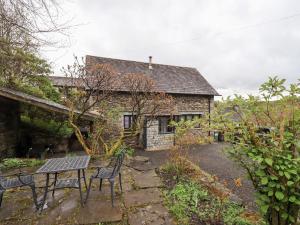 a stone house with a table and chairs in front of it at The Old Chapel in Windermere