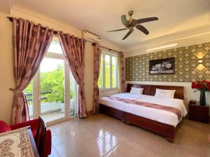 una camera da letto con un letto e un ventilatore a soffitto di Dai Long Hotel a Da Nang