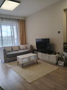 a living room with a couch and a tv at 2 Bedroom Aries Residence, Mbsa Rd in Nairobi