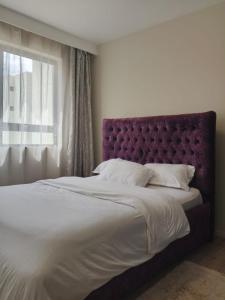 a bedroom with a large bed and a window at 2 Bedroom Aries Residence, Mbsa Rd in Nairobi