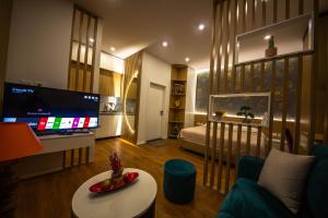 a living room with a tv and a couch and a table at Downtown Boutique Studios in Tirana