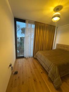 a bedroom with a bed and a large window at San Pietro Villa 7 in Draçi