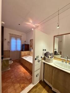 a bathroom with a tub and a sink and a mirror at Al Riccio in Cocconato