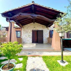 a house with a building with a wooden roof at Villa Arbatax 200m from the Sea with Parking in Àrbatax