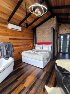 a bedroom with a large bed and a bath tub at Chalé Recanto da Coruja 2 in Barracão +31 photos