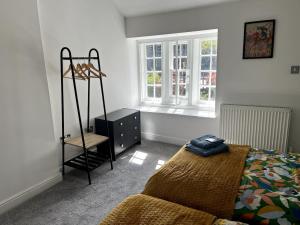 ein Schlafzimmer mit einem Bett, einer Kommode und einem Fenster in der Unterkunft Railway Cottage Horsforth in Horsforth