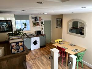 a kitchen with a table and a washing machine at Railway Cottage Horsforth in Horsforth