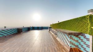 a boardwalk with a green wall and a bench at Radisson Hotel Bareilly Airport in Bareilly
