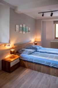 a bedroom with a bed with a blue bedspread and a table at VIA MALA Apartment in Kirchensittenbach