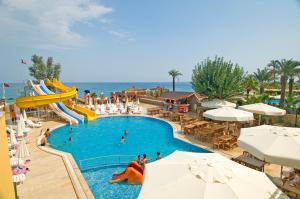 a pool at a resort with people swimming in it at Club Hotel Sunbel in Kemer