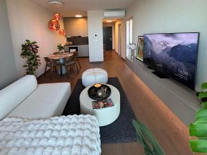 een woonkamer met een witte bank en een flatscreen-tv bij Luxury Apartment 34th Floor Eurovea Tower in Ovsište