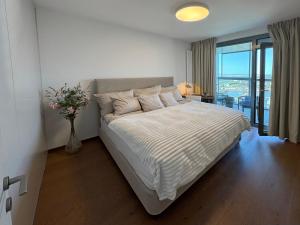 een slaapkamer met een bed met een vaas met bloemen bij Luxury Apartment 34th Floor Eurovea Tower in Ovsište