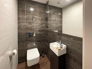een badkamer met een wit toilet en een wastafel bij Luxury Apartment 34th Floor Eurovea Tower in Ovsište +9 foto's