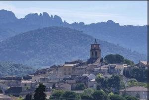 a village with a church on top of a mountain at Gîte Nomad Sablet in Sablet