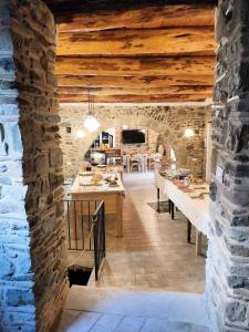 a kitchen with a stone wall and wooden ceilings at La Casa della Filanda in Belmonte Calabro