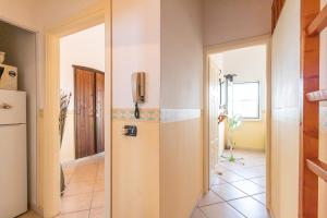 a hallway with a door to a kitchen with a refrigerator at Appartamento 1P in Villa De Santis- Gallipoli in Il Monte