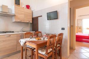 a kitchen with a wooden table with chairs and a sink at Appartamento 1P in Villa De Santis- Gallipoli in Il Monte +11 photos