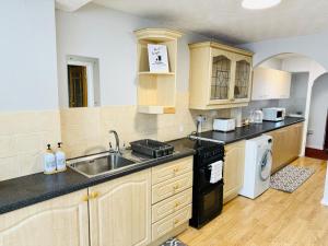 a kitchen with a sink and a stove at Professional 4BR House - Lace Market, Uni, QMC, City Centre & M1 - Sleeps 8 in Nottingham