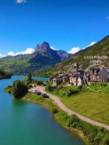 an aerial view of a resort on a river with mountains in the background at CASA PIXURRI en Lanuza compuesta de 5 apartamentos turísticos en casona pirenaica, a 10 minutos de las ESTACIONES de ESQUÍ de FORMIGAL-PANTICOSA in Lanuza