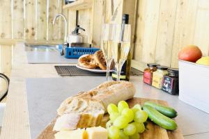a loaf of bread and grapes and a glass of wine at Solo Glamping Pod - Sleeps 4 - Northumberland in Morpeth