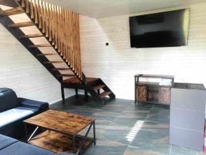 a living room with a tv and a couch and a table at Domek przy plaży na mazurach in Orzysz